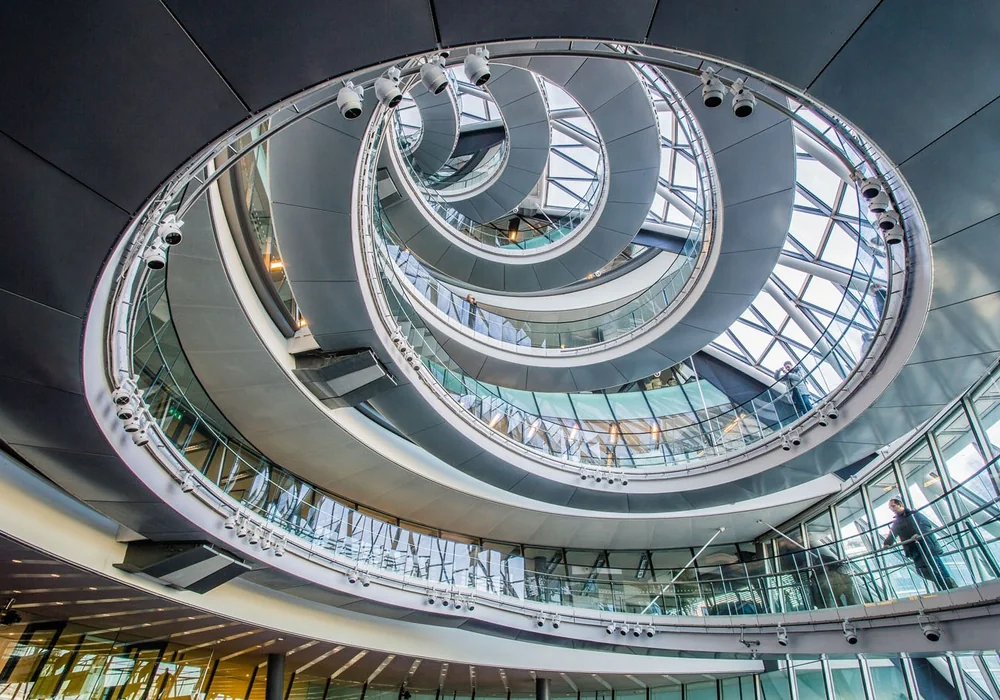 Spiral atrium ramp ascending through multiple visible loops toward a skylight