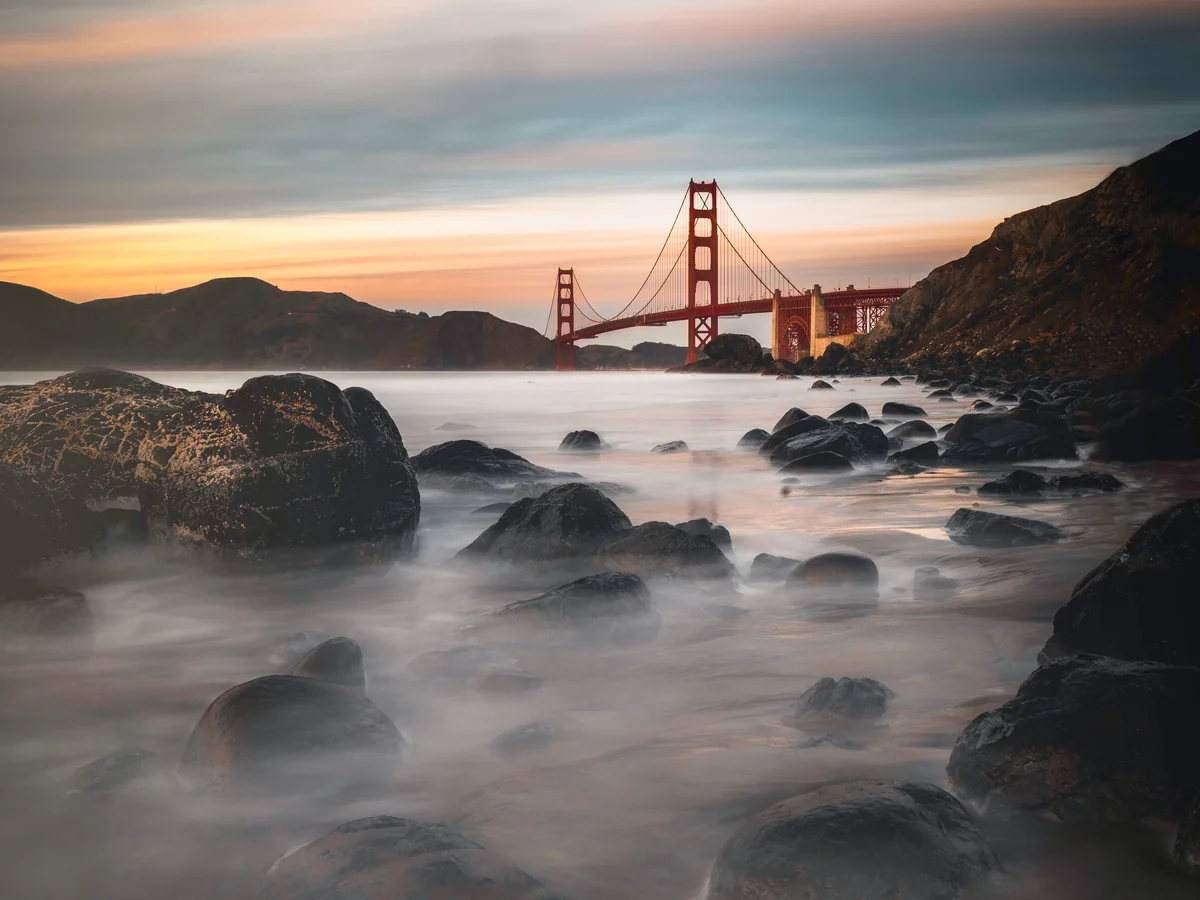 Golden Gate Bridge at sunset, viewed from the Pacific coastline looking west